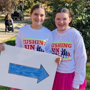 Two young volunteers holding signs at the Cushing Fun Run