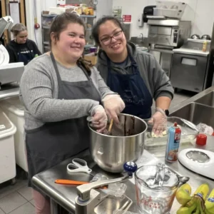 Two students cooking in the Cushing Cafe kitchen