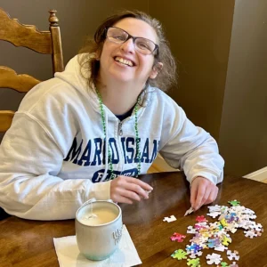Cushing adult doing a puzzle at her residence