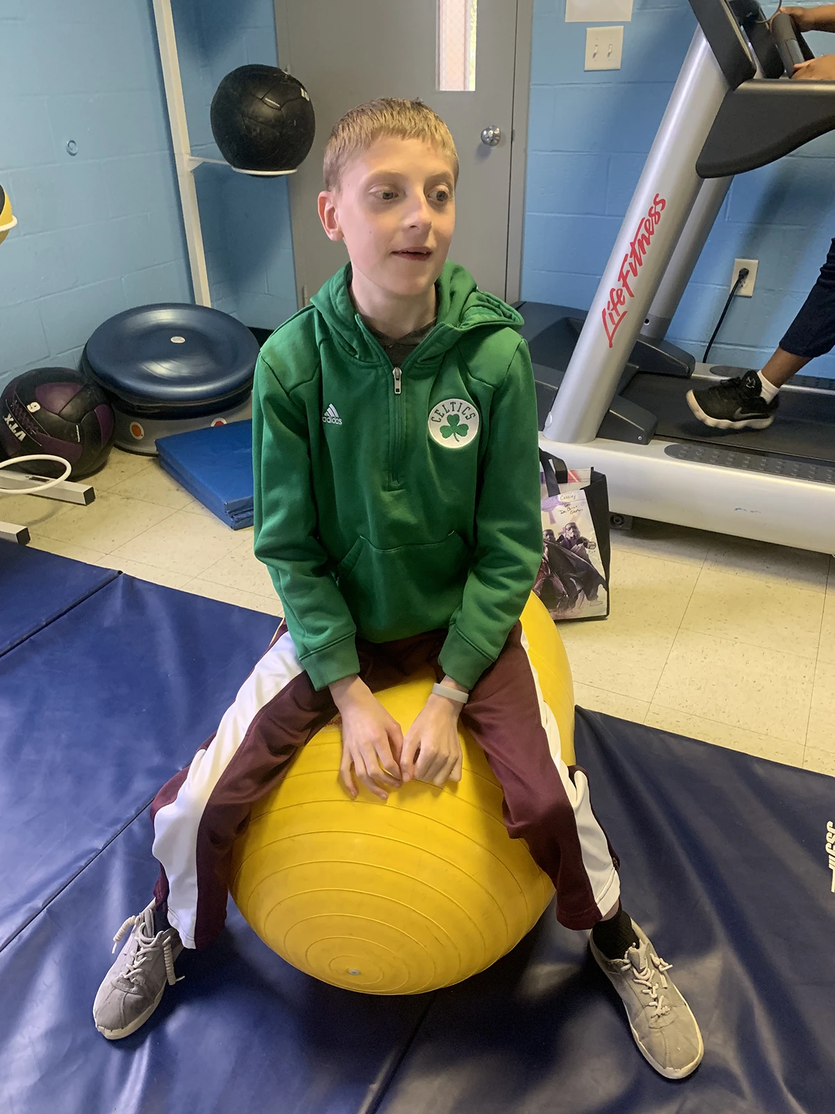 Cushing student doing physical therapy on an exercise ball.