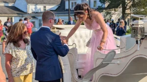 Cushing Student gets a hand existing a horse drawn carriage at Prom
