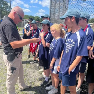 Students speaking with police officer at special olympics