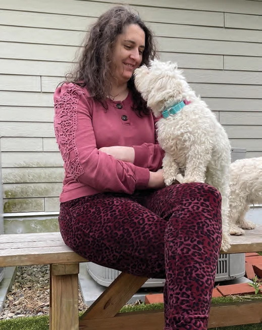 Emma Sage bonding with a small white dog at the Scituate Animal Shelter.