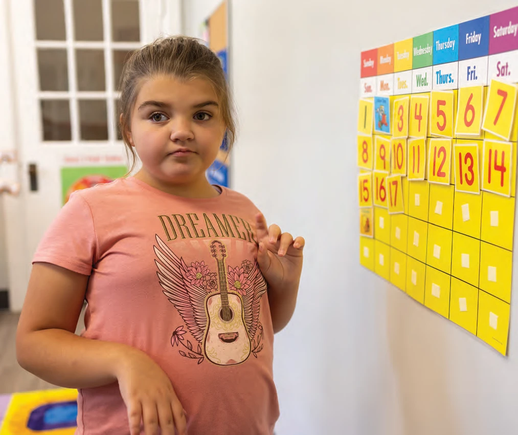 Savannah Joy updating her classroom calendar.