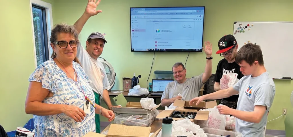 Case manager Susan Giusti, Tim Rochon, job coach Bob MacKinnon, Eoin Coyne and Tyler English preparing packages for homeless families.