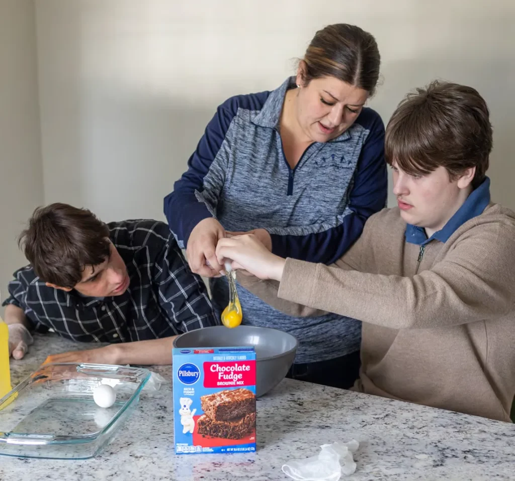 Residents Dylan Singer and Luke Lee
make brownies with teaching assistant
Amanda Cleary.