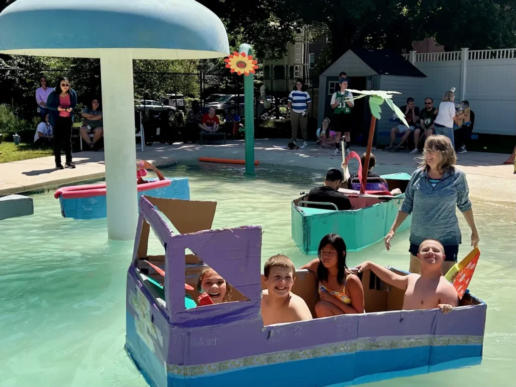 Four students sit in a floating boat