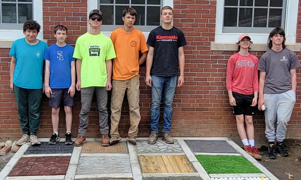 Eagle Scout Joe Hamblin (orange shirt) and his troop build a sensory path for the Cushing community.