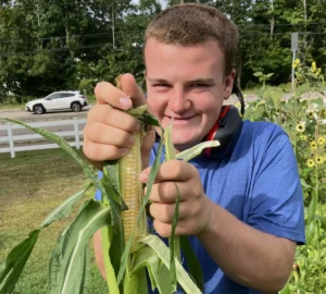 Patrick Bradbury picking corn grown in the Cushing garden