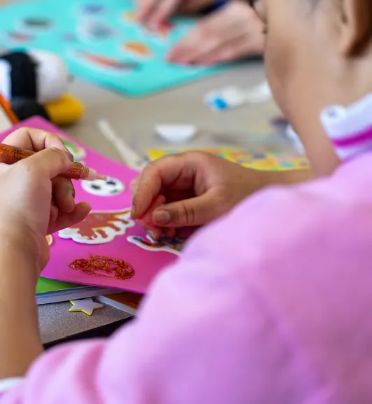 Student Anaya Figueroa places stickers on a collage.