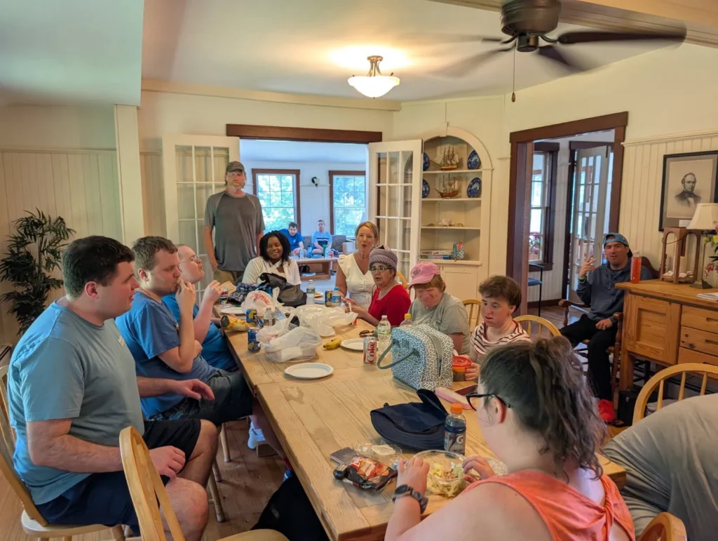 Cushing adults sitting around a table together on their Duxbury retreat