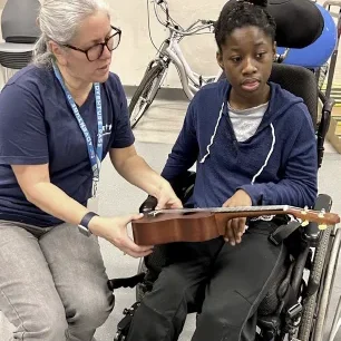 Cushing Teacher with a student using an ukulele